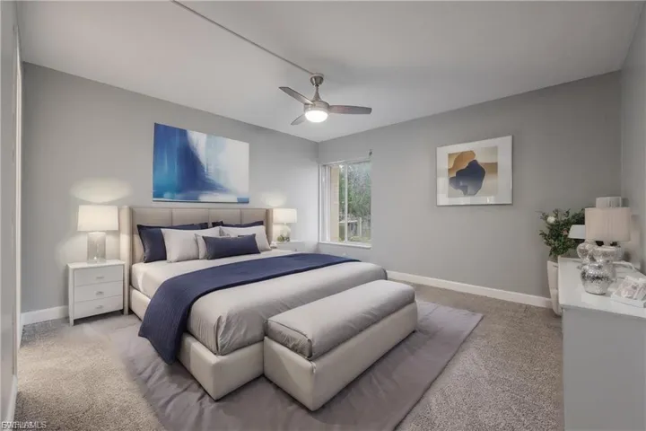 Carpeted bedroom with ceiling fan and baseboards