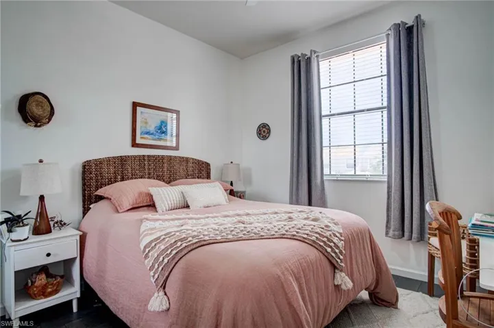 Bedroom with dark hardwood / wood-style flooring and multiple windows