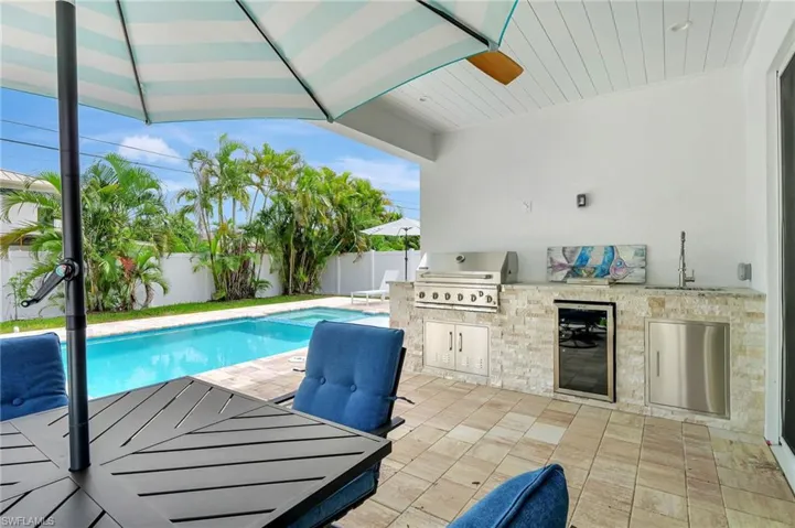 View of pool featuring grilling area, sink, a patio area, and exterior kitchen
