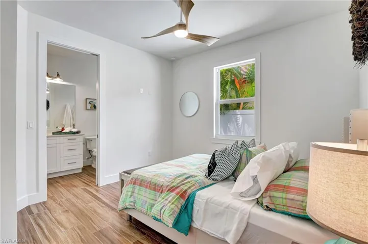 Bedroom featuring ensuite bath, ceiling fan, and light hardwood / wood-style floors