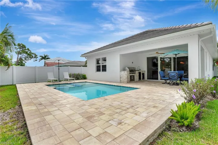 View of pool featuring a patio area, ceiling fan, and a grill
