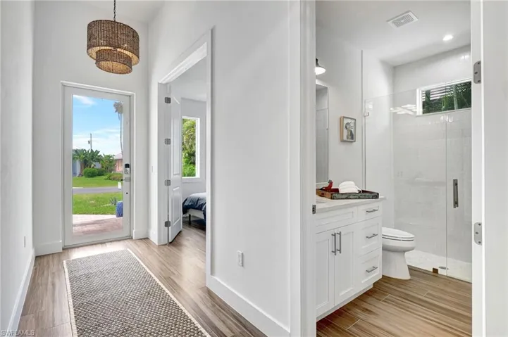 Bathroom with vanity, toilet, a wealth of natural light, and walk in shower