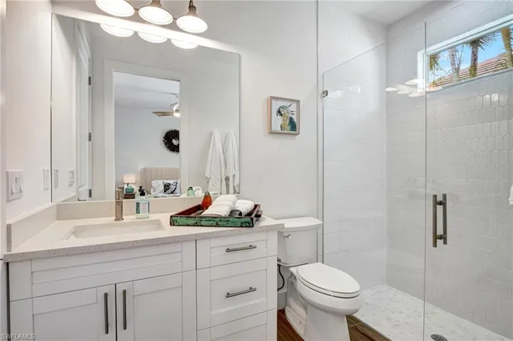 Bathroom with vanity, walk in shower, and toilet
