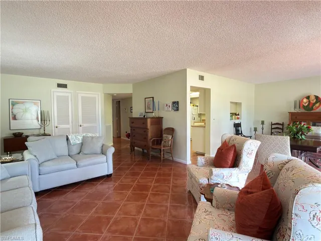 Living room featuring a textured ceiling and tile patterned flooring