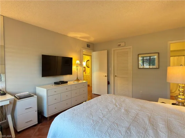 Bedroom featuring a textured ceiling, a closet, and dark tile patterned flooring