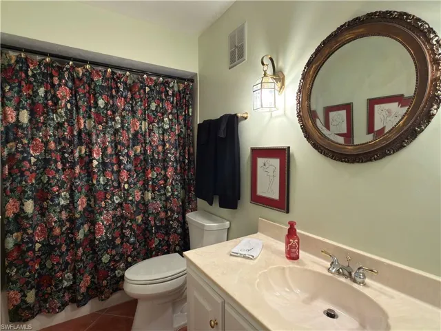 Full bathroom with vanity, a shower with shower curtain, and tile patterned floors
