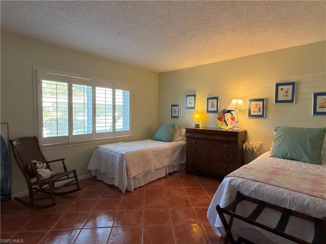 Tiled bedroom featuring a textured ceiling