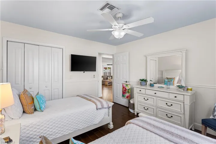 Bedroom featuring ceiling fan, a closet, and dark hardwood / wood-style flooring