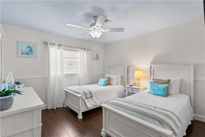 Bedroom with dark hardwood / wood-style floors and ceiling fan