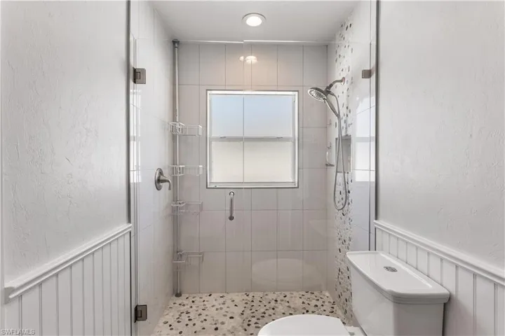 Bathroom featuring a tile shower and toilet