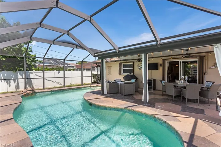 View of swimming pool featuring ceiling fan, a lanai, an outdoor hangout area, and a patio