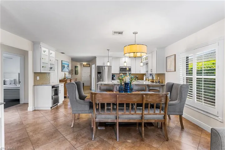 Dining space with wine cooler and light tile floors