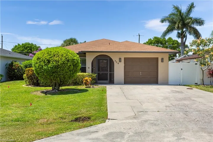 Ranch-style house featuring a front lawn and a garage