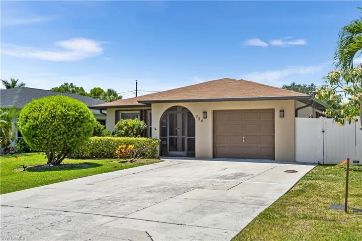 Ranch-style home featuring a garage and a front lawn
