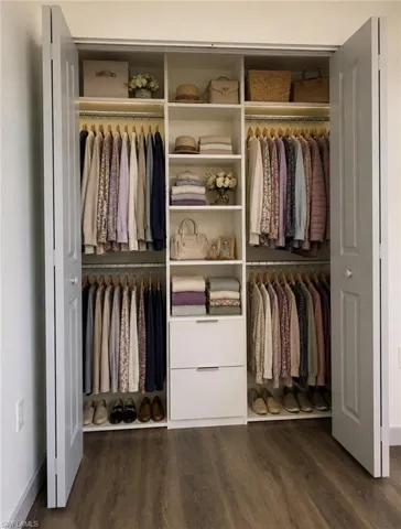 Built-in closet organization system featuring white cabinetry, multiple shelving units, and two integrated drawers