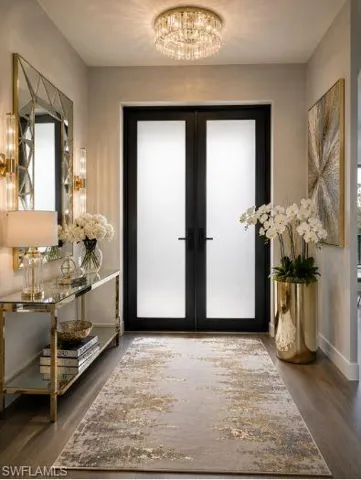 Entryway featuring double doors with frosted glass panels, wood-finish flooring, and a crystal flush-mount ceiling fixture