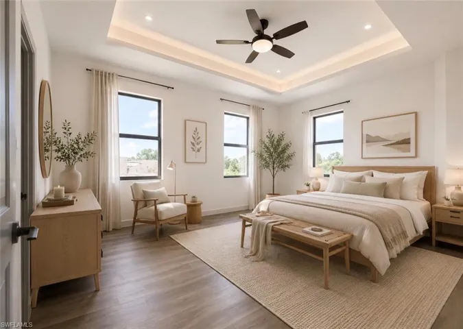 Spacious master bedroom w/space for sitting area featuring tray ceiling and a ceiling fan Virtually Staged