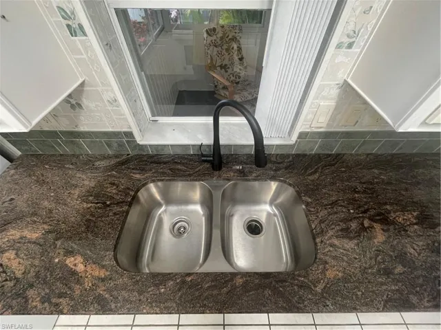 Kitchen view of a sink and dark stone countertops