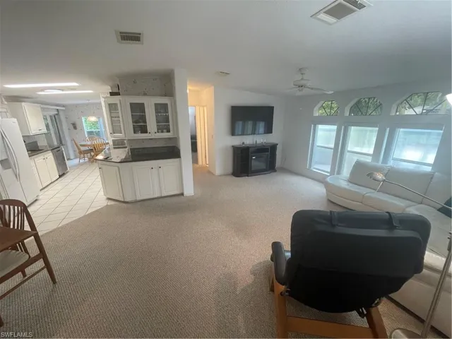 Living area featuring light carpet and light tile patterned flooring