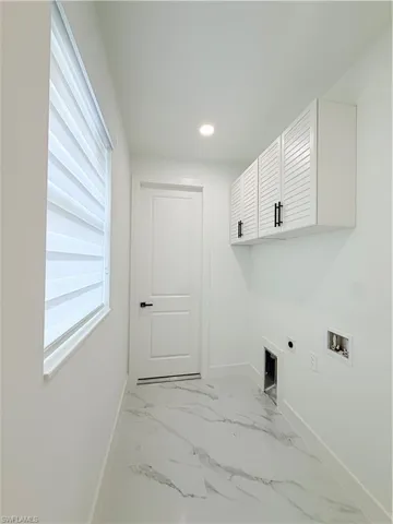 White louvered cabinetry, recessed lighting, and a window with horizontal blinds