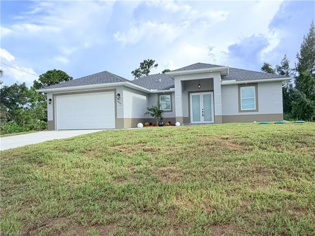 Contemporary exterior with an attached two-car garage, covered entry, and double front doors