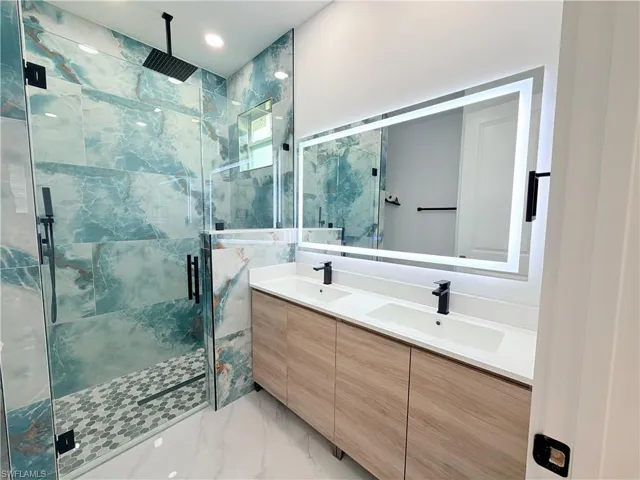 Dual vanity with undermount sinks, illuminated mirror, and wood-finish cabinetry