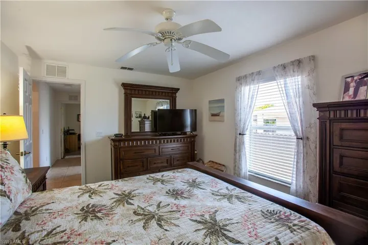 Tiled bedroom with ceiling fan and visible vents