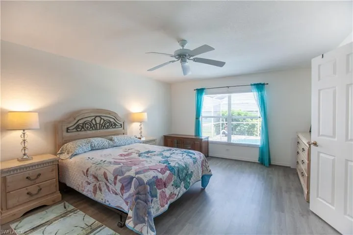 Bedroom with light wood-style floors, a ceiling fan, and baseboards