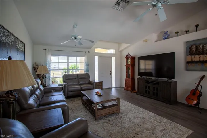 Living room with ceiling fan, visible vents, a healthy amount of sunlight, and wood finished floors