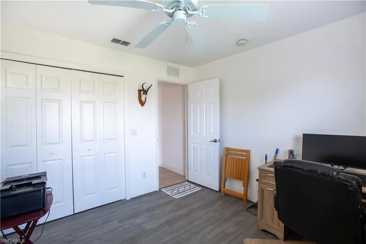 Office featuring baseboards, a ceiling fan, wood finished floors, and visible vents