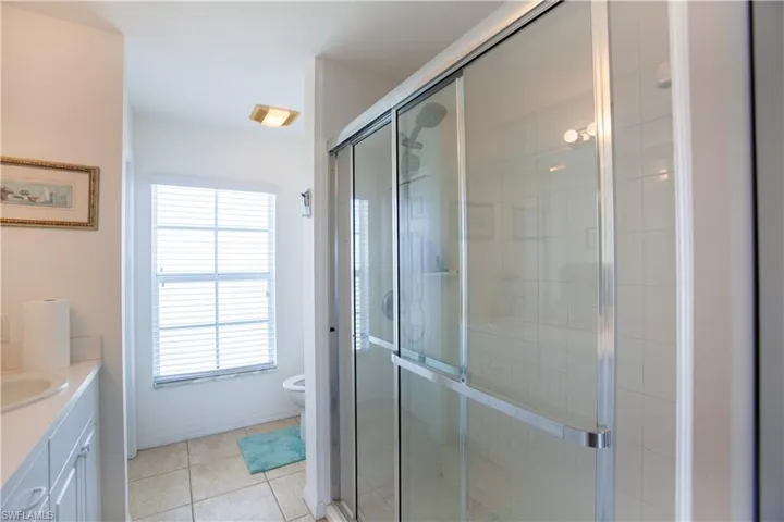 Full bath with vanity, tile patterned flooring, a shower stall, and toilet