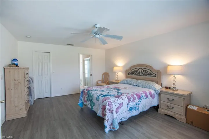 Bedroom featuring a ceiling fan, visible vents, wood finished floors, baseboards, and a closet