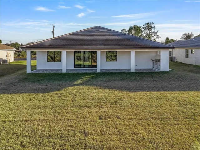Back of property with a yard, a patio area, and stucco siding