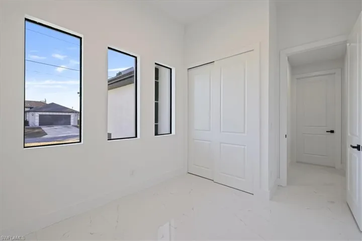 Unfurnished bedroom featuring light marble finish flooring and a closet