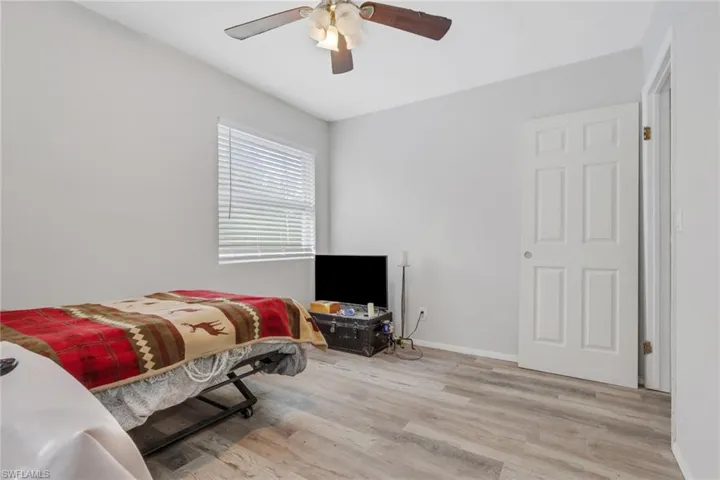 Bedroom with a ceiling fan and light wood-style flooring