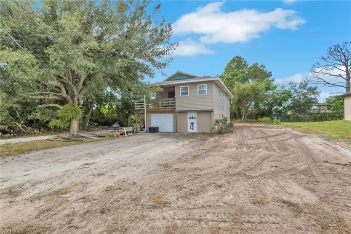 View of home's exterior with a balcony, a garage, and driveway