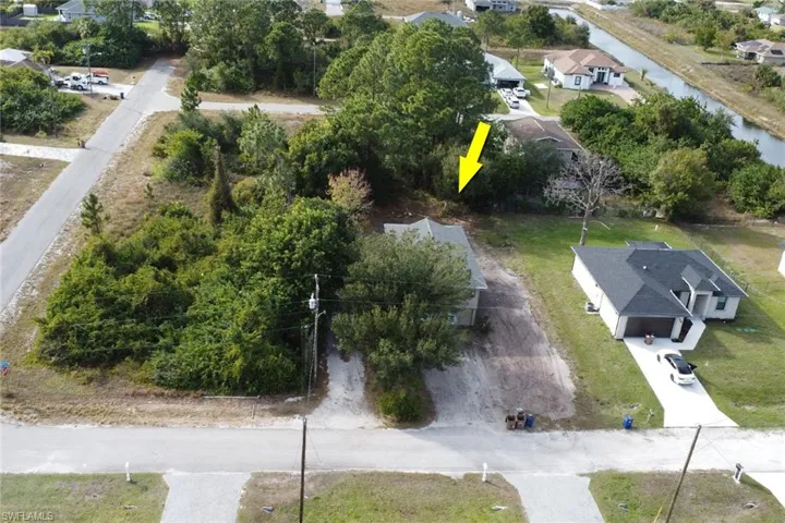 Aerial view of property and surrounding area featuring nearby suburban area