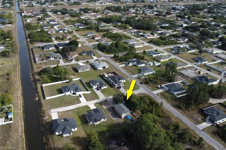 Aerial view of property and surrounding area featuring nearby suburban area