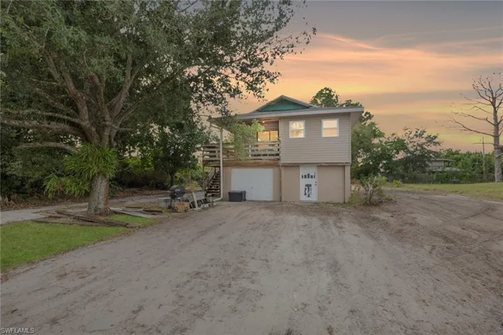 View of front of house with a balcony, stairway, driveway, and an attached garage
