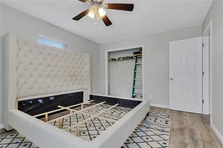 Bedroom with a ceiling fan, light wood-style flooring, and a closet