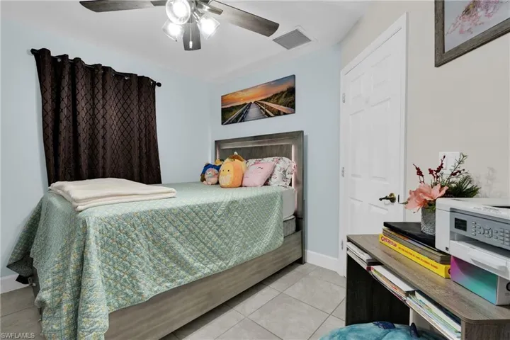 Bedroom featuring light tile patterned floors and a ceiling fan