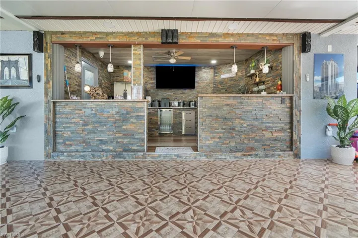 Bar featuring a textured wall and a ceiling fan