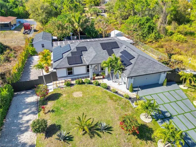 Aerial view of property and surrounding area featuring a tree filled landscape