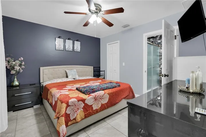 Bedroom with a ceiling fan, light tile patterned floors, and a closet