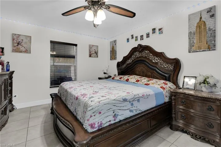 Bedroom with a ceiling fan and light tile patterned flooring