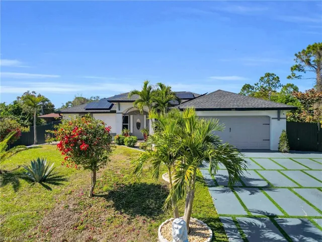 View of front of property with solar panels, concrete driveway, an attached garage, stucco siding, and a shingled roof