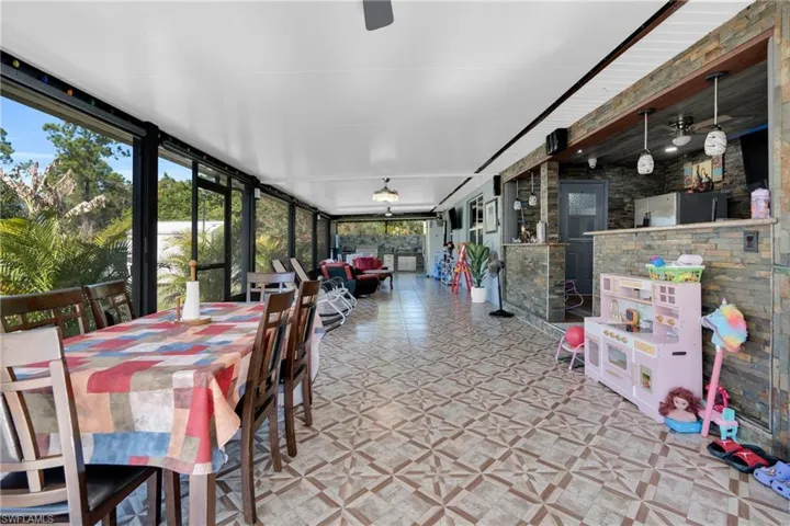 Sunroom with ceiling fan, outdoor dining space, and outdoor lounge area
