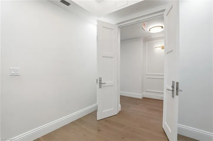 Corridor featuring light wood-type flooring and baseboards