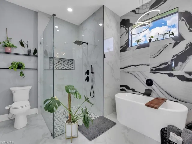Bathroom with tile floors, separate shower and tub, and toilet