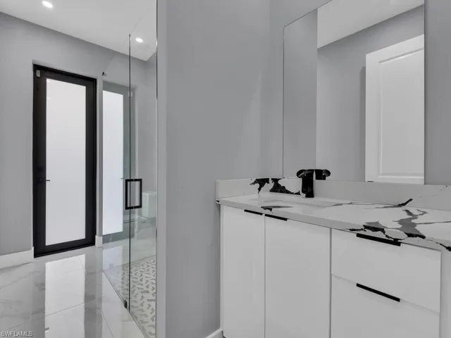 Bathroom with walk in shower, tile flooring, and vanity